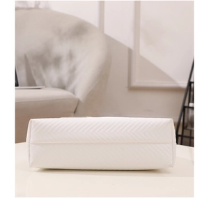 Detail view of the white PU leather crossbody bag featuring a classic V-shaped chevron pattern