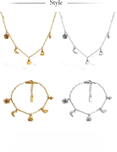 Detail of gold and silver jewelry set featuring rose, moon, and penguin charms