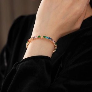 Close-up of a luxury gold tennis bracelet featuring multi-colored zircon stones
