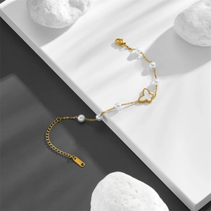 Golden stainless steel bracelet featuring white pearl charms and a butterfly pendant