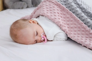 Dettaglio della coperta per neonati rosa e grigia con texture a rilievo per il sonno