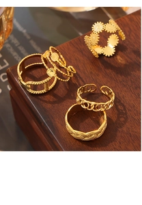 Nahaufnahme goldener geometrischer Ringe auf Holzständer mit Ketten- und Blumenmustern
