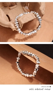 Close-up of irregular silver beads with a polished liquid metal finish and lobster clasp