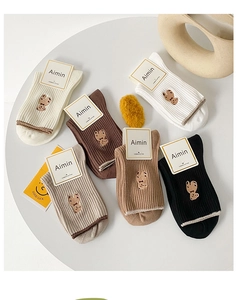 Détail de chaussettes en coton peigné en six couleurs neutres avec broderie d'ours mignonne