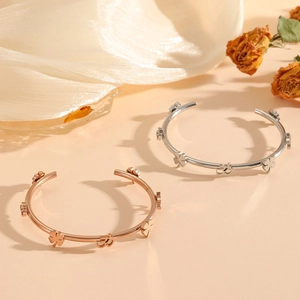Polished stainless steel open bracelets with lucky clover and Om symbols in silver and rose gold
