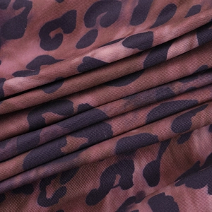 Macro shot of brown and purple leopard print on ribbed knit fabric showing texture
