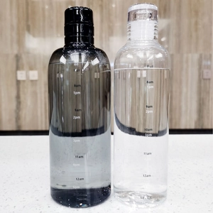 Detail of transparent water bottles with time markers in dark grey and clear finishes