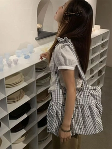 Minimalist blue and white checkered tote bag with black bow and drawstring pleat detail