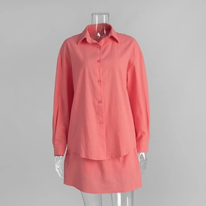Detail of coral cotton two-piece set featuring long sleeve shirt and mini skirt