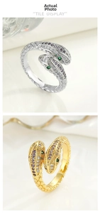 Close-up of double-headed snake rings in gold and silver with colorful zircon inlay