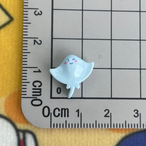 Detailed size view of a small blue cartoon stingray resin accessory on a scale mat