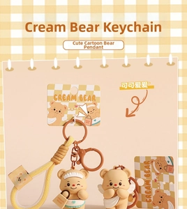 Close-up of Cream Bear keychain charms with woven wristlet and soft PVC apron detail