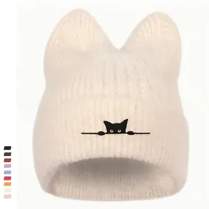 Detailaufnahme der beige Strickmütze mit Katzenohren und schwarzer Katzenstickerei