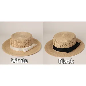 Hand-woven raffia boater hat with hollow design and decorative silk ribbon