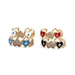 Detailed view of copper gold rings with colorful enamel hearts and cubic zirconia stones