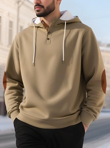 Detail of khaki hoodie featuring button placket, white lining and elbow patches