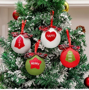 Macro detail of knit Christmas ornaments with holiday embroidery hanging on a tree