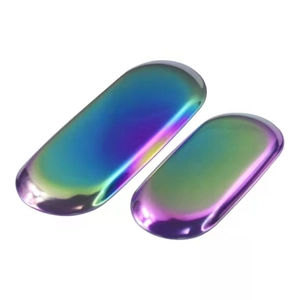 Macro detail of two oval stainless steel trays with vibrant rainbow electroplated finish
