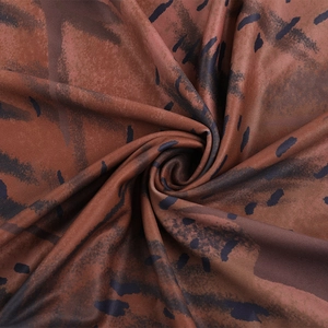 Close-up of soft printed fabric with deep brown and black irregular patterns for dresses