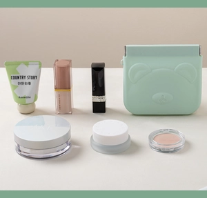 Mint green silicone cosmetic pouch with embossed bear face and beauty accessories