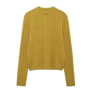 Detailed back view of yellow cable knit sweater showing thick woven texture and ribbed hem