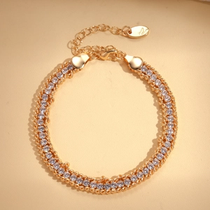 Detail of double-row gold chain bracelet with round white zircons and lobster clasp closure