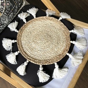 Dettaglio macro della decorazione da parete boho intrecciata con nappe e perle