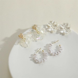 Three-pair earring set featuring white floral, heart petals, and pearl hoops in gold