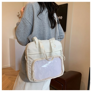 Detail of white nylon tote bag featuring front mesh pocket and side drawstring accents