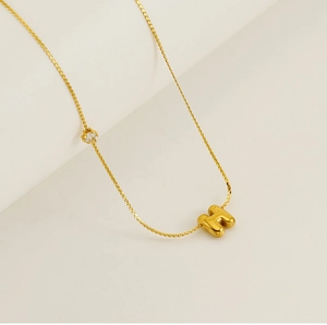 Detailed close-up of gold stainless steel H-pendant necklace with round zircon stone