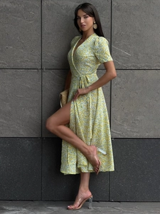 Detail of yellow floral wrap midi dress showing V-neck, short sleeves and side slit design