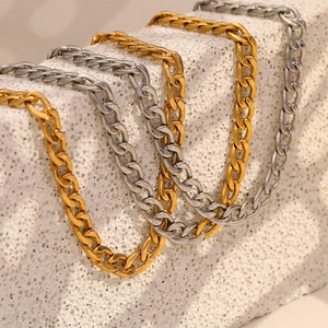 Minimalist 18K gold and silver polished stainless steel Cuban link necklaces on stone