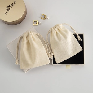 Detail view of cotton jewelry storage pouches and gift box with soft black lining