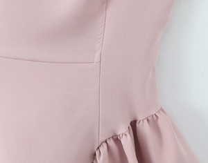 Detail shot of pink dress fabric showing fine stitching and pleated ruffle texture