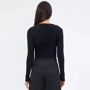 Back view of a slim-fit black knit cardigan and high-waisted striped trousers outfit
