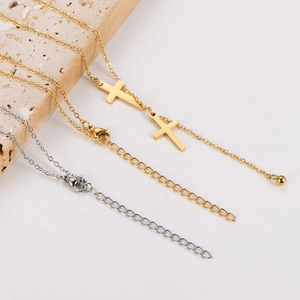 Detail of gold and silver stainless steel cross necklaces on a textured stone base