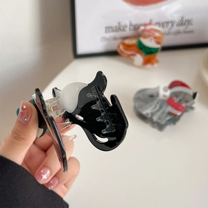 Chic black and white acetate cat shaped hair claw clip held in hand for women