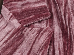 Detailed macro view of dark pink velvet fabric showing rich texture and striped grain