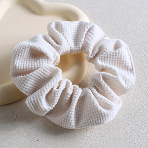 Close-up of white waffle texture scrunchie on a decorative cloud tray accessory