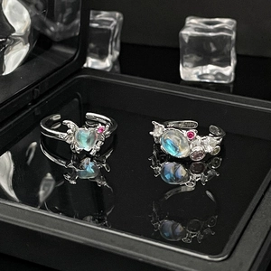 Close-up of silver moonstone rings with heart and oval gems in a black jewelry box