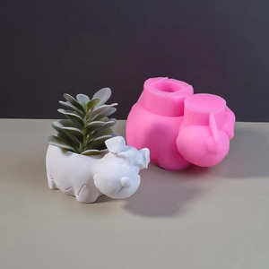 Pink silicone mold and finished white dog-shaped succulent planter for DIY craft projects