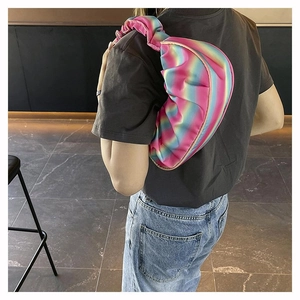 Detail of colorful rainbow pleated shoulder bag with wide strap on model's shoulder