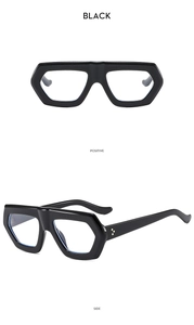 Detailed view of thick black geometric eyeglass frames with silver rivet accents and clear lenses