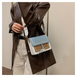 Detail of color-block crossbody bag with wide ethnic strap and V-shaped stitching