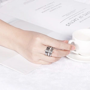 Detail of Roman numeral multi-layer rings in rose gold and silver on a finger