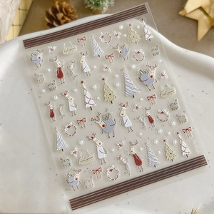 Christmas nail art stickers with reindeer and tree designs on marble base