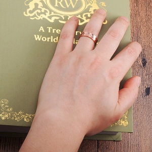 Classic wide copper ring with hammered texture worn on hand over vintage books