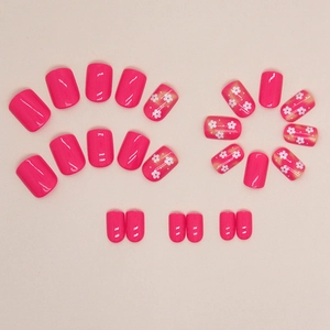 Short square pink press-on nails with white flower patterns and yellow smudge effect