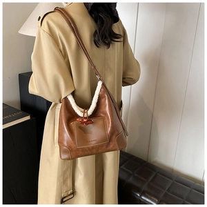 Detail of vintage brown bucket bag with white shearling trim and toggle button closure
