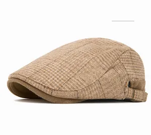 Detail of camel plaid ivy cap showing tweed texture and adjustable metal side buckle